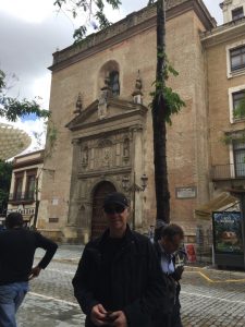 Mark waiting at ATM. Mosque/Church behind.