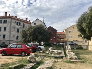 Roman ruins butting up against car park.